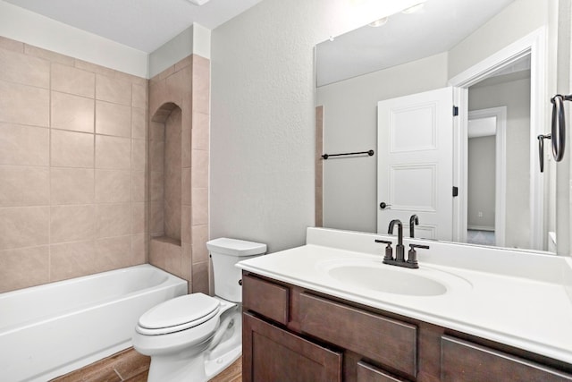 full bathroom with toilet, tiled shower / bath combo, and vanity