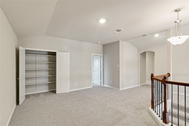 interior space with light colored carpet and vaulted ceiling