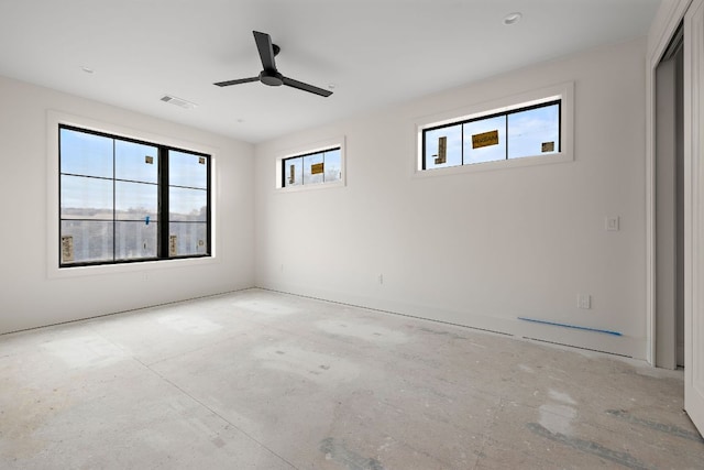 empty room with a wealth of natural light, visible vents, and a ceiling fan