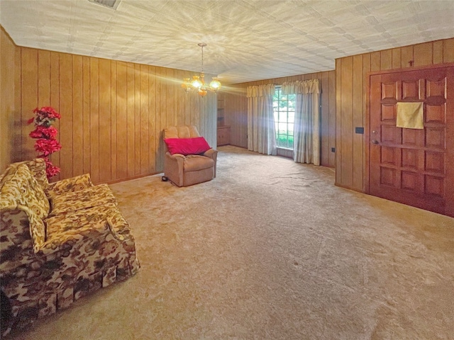 sitting room featuring wooden walls, light colored carpet, and a chandelier