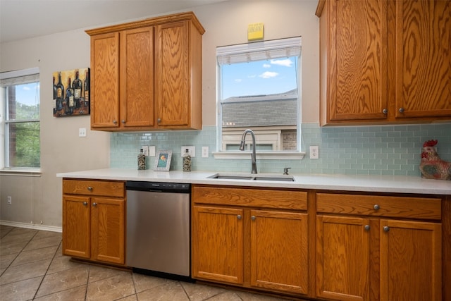 kitchen with stainless steel dishwasher, sink, tasteful backsplash, and light tile flooring