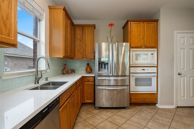 kitchen featuring sink, backsplash, stainless steel appliances, light tile flooring, and light stone countertops