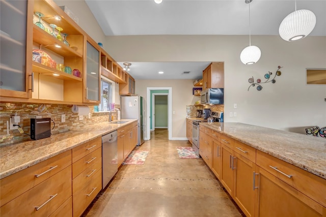 kitchen featuring pendant lighting, light stone counters, backsplash, stainless steel appliances, and sink