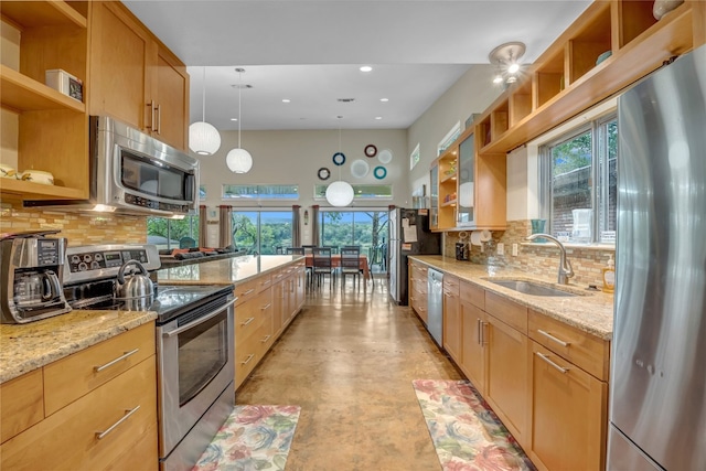 kitchen featuring appliances with stainless steel finishes, tasteful backsplash, sink, and pendant lighting