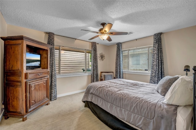 bedroom featuring a textured ceiling, ceiling fan, and light colored carpet