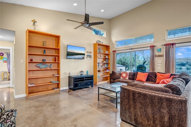 living room with ceiling fan and a high ceiling