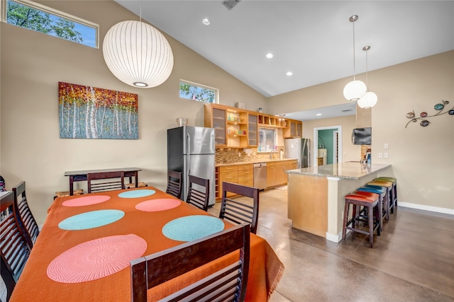 dining area with concrete floors and high vaulted ceiling