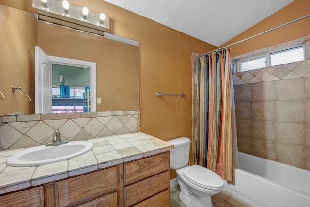 full bathroom featuring tile floors, vaulted ceiling, toilet, vanity, and shower / bath combo with shower curtain