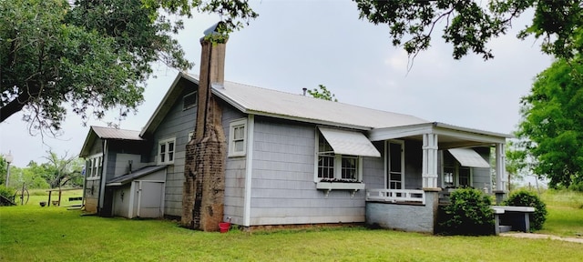 view of property exterior featuring metal roof, a yard, and a chimney