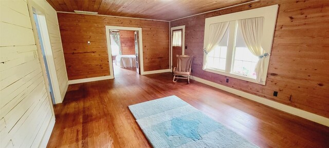 interior space featuring wood walls, wood ceiling, baseboards, and wood finished floors