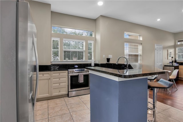 kitchen featuring appliances with stainless steel finishes, a wealth of natural light, and light tile floors