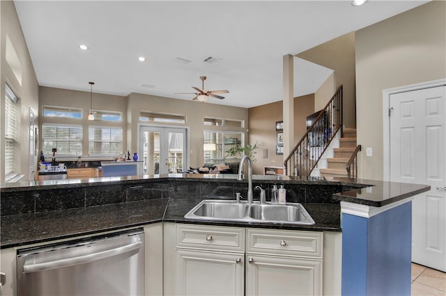 kitchen featuring light tile floors, dark stone counters, ceiling fan, dishwasher, and sink