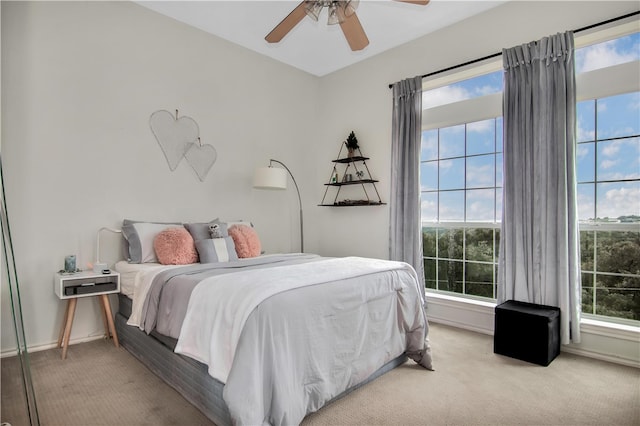 carpeted bedroom with ceiling fan and multiple windows