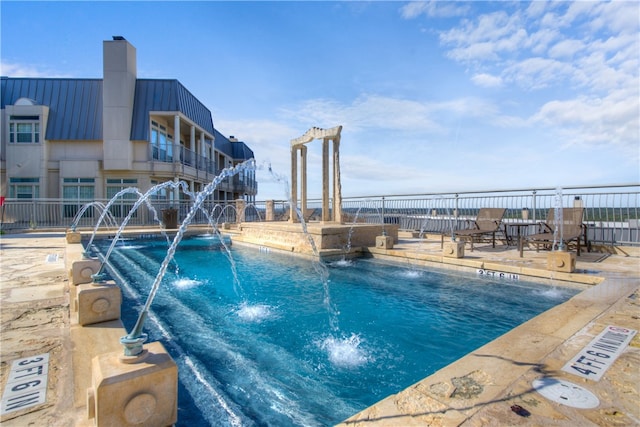 view of pool with a patio area and pool water feature