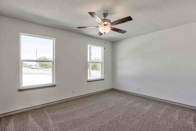 carpeted empty room with ceiling fan and a textured ceiling