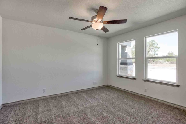 empty room with carpet floors, ceiling fan, and a textured ceiling