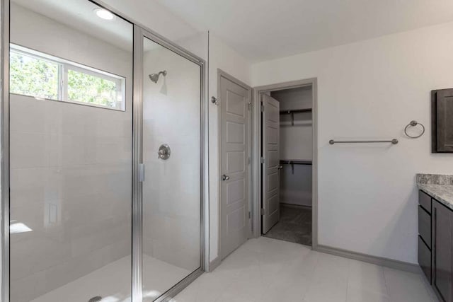 bathroom featuring vanity, a shower with door, and tile flooring