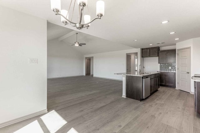 kitchen with pendant lighting, vaulted ceiling, light hardwood / wood-style flooring, and ceiling fan with notable chandelier