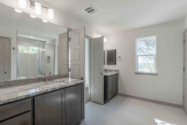 bathroom with vanity with extensive cabinet space, tile floors, and a wealth of natural light