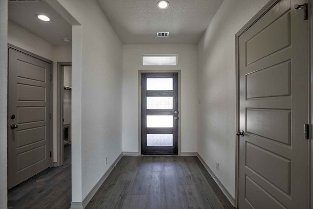 entrance foyer with dark hardwood / wood-style floors and a textured ceiling