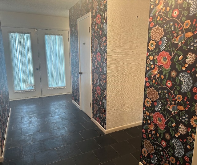 corridor featuring french doors, dark tile floors, and a wealth of natural light