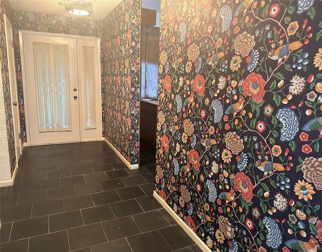 hall with dark tile floors and a textured ceiling