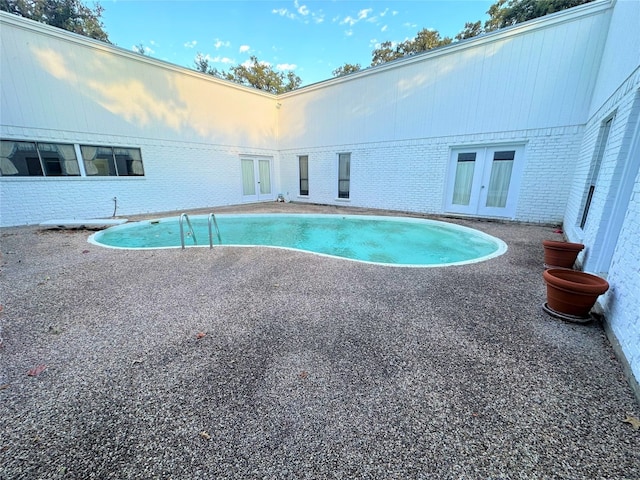 view of swimming pool featuring french doors and a patio