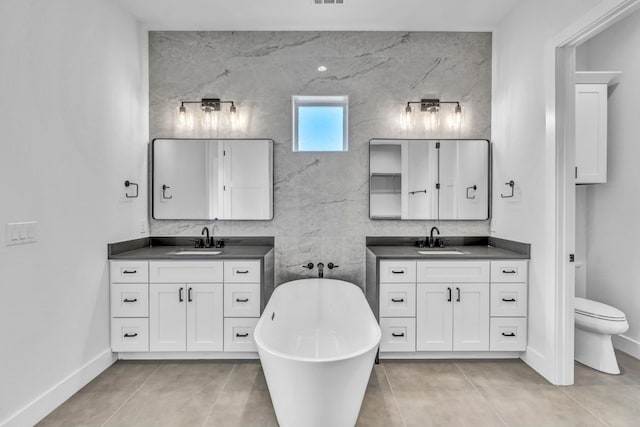 bathroom featuring tile walls, toilet, dual vanity, and tile flooring