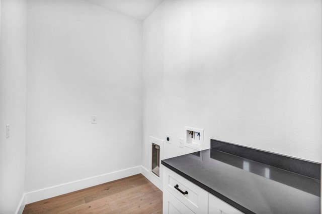 laundry area with light hardwood / wood-style floors, cabinets, hookup for an electric dryer, and hookup for a washing machine