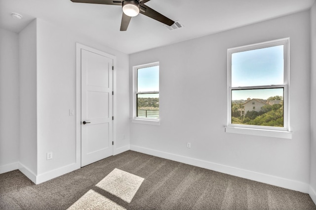 carpeted spare room featuring ceiling fan