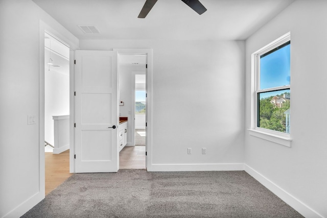 unfurnished bedroom with ceiling fan and light colored carpet