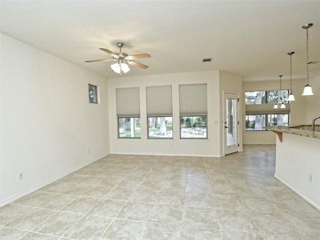 unfurnished living room with ceiling fan and light tile floors