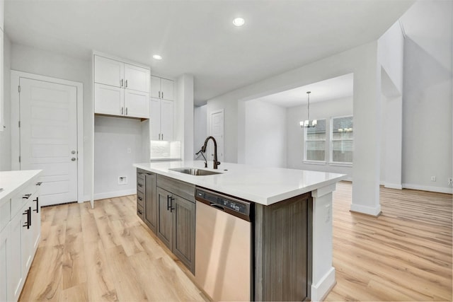 kitchen featuring sink, a chandelier, dishwasher, white cabinetry, and light wood-type flooring