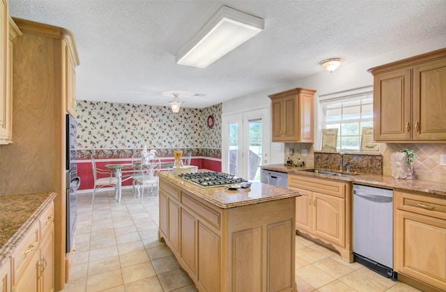 kitchen with appliances with stainless steel finishes, a wealth of natural light, and light tile flooring