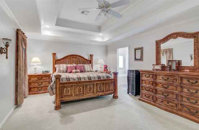 bedroom with light carpet, ornamental molding, ceiling fan, and a tray ceiling