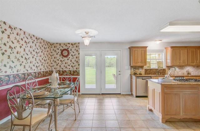 kitchen featuring backsplash, light tile floors, appliances with stainless steel finishes, and a wealth of natural light