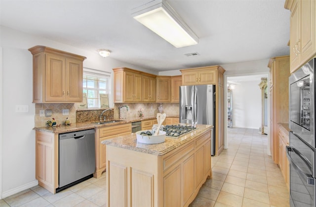 kitchen with light tile floors, light stone counters, a kitchen island, backsplash, and stainless steel appliances