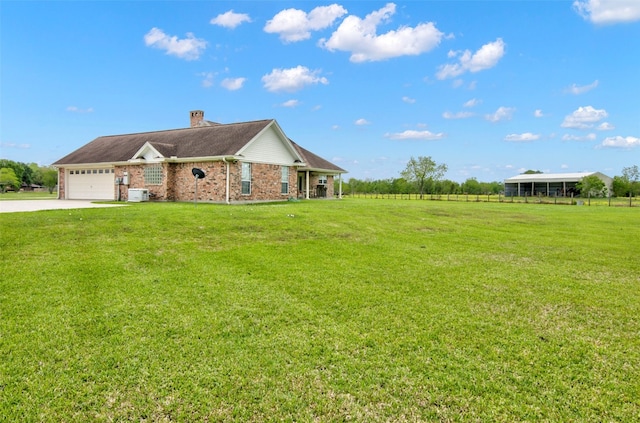 single story home with central AC, a front lawn, and a garage