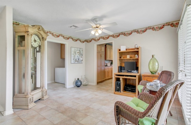 living room with ceiling fan, washer / dryer, and light tile flooring