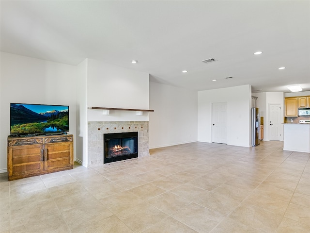 living room featuring a tile fireplace and light tile patterned floors