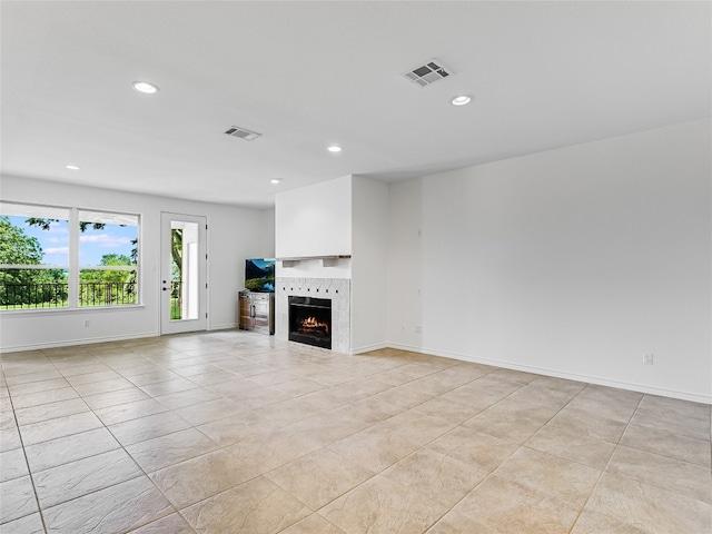 unfurnished living room with a tiled fireplace and light tile patterned floors