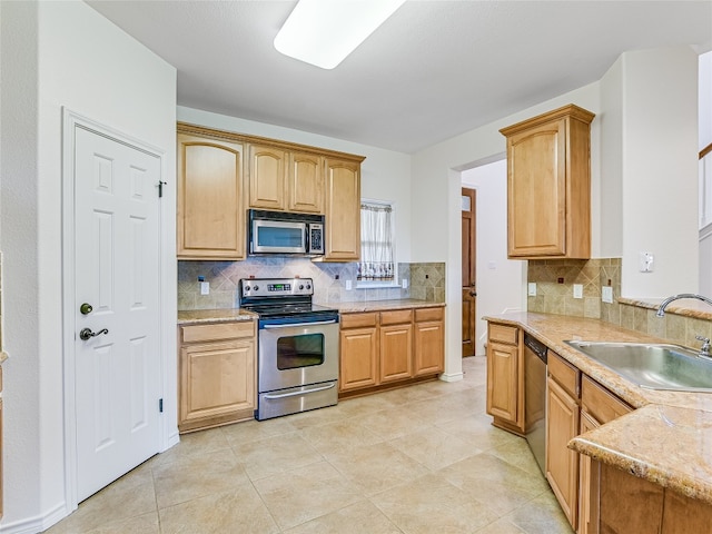 kitchen with sink, light tile patterned floors, backsplash, and stainless steel appliances