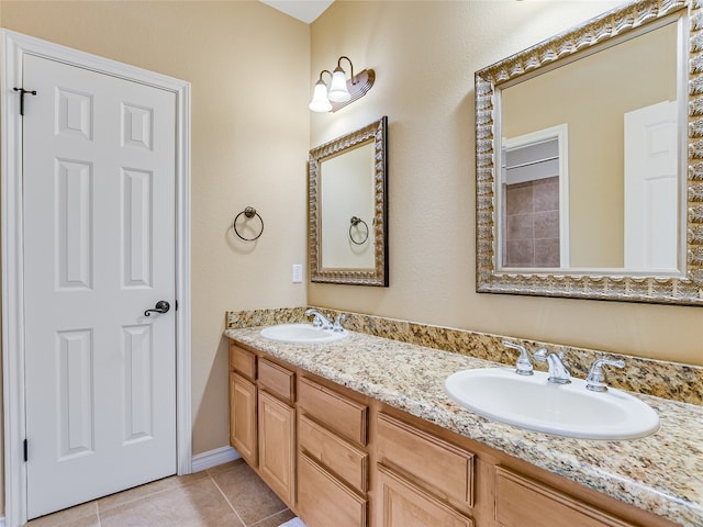 bathroom with tile patterned floors and dual bowl vanity