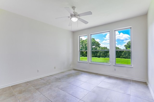 tiled empty room featuring ceiling fan