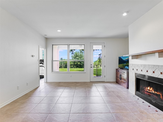 539 Colovista Pkwy Unit C101, Bastrop, TX 78602 - unfurnished living room featuring a warm lit fireplace, light tile patterned flooring, baseboards, and recessed lighting