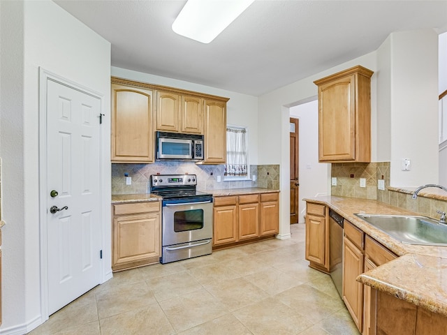 539 Colovista Pkwy Unit C101, Bastrop, TX 78602 - kitchen featuring stainless steel appliances, a sink, tasteful backsplash, and light stone countertops