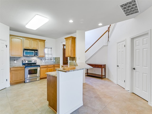 539 Colovista Pkwy Unit C101, Bastrop, TX 78602 - kitchen featuring appliances with stainless steel finishes, light stone countertops, decorative backsplash, a peninsula, and recessed lighting