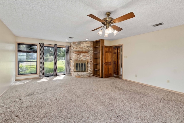 unfurnished living room with a textured ceiling, light colored carpet, ceiling fan, and a fireplace