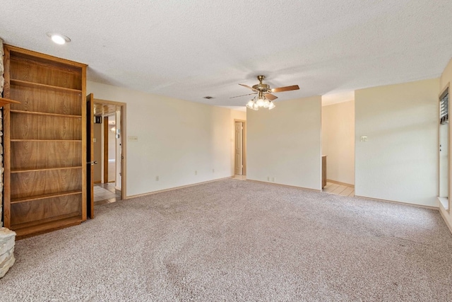 carpeted empty room featuring a textured ceiling and ceiling fan