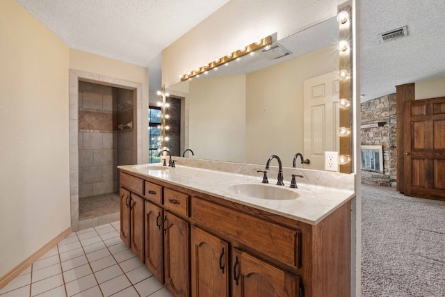 bathroom featuring dual vanity, a textured ceiling, tile floors, and a fireplace